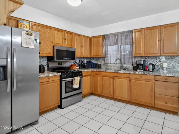 a kitchen with a refrigerator a stove top oven a sink and cabinets
