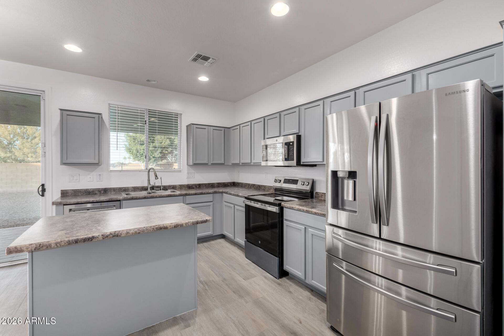 836 Constance Way Phoenix, AZ 85042 - Photo 13 of 51 a kitchen with stainless steel appliances granite countertop a refrigerator a sink dishwasher a stove and white countertops with wooden floor