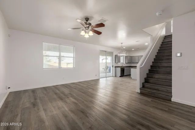 a kitchen with stainless steel appliances granite countertop a refrigerator a sink dishwasher a stove and white countertops with wooden floor