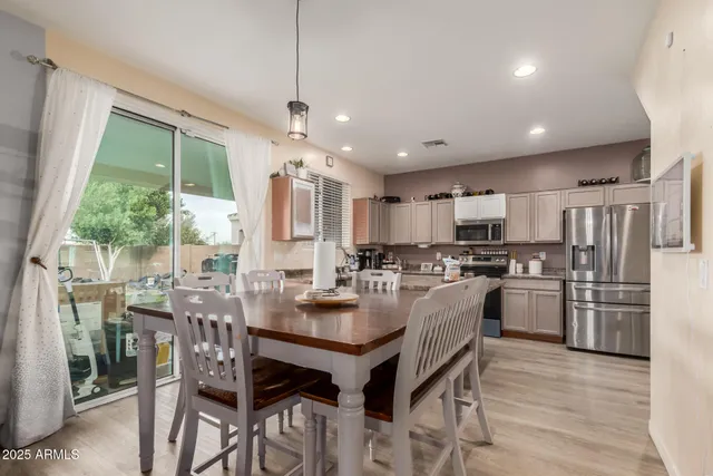 a kitchen with refrigerator a stove and chairs