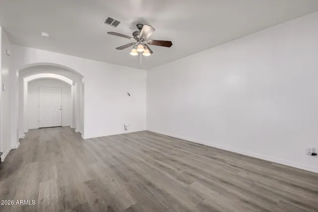 a view of an empty room with a window and wooden floor
