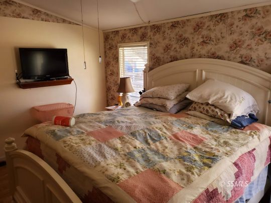8926 Caliente Bodfish Road Caliente, CA 93518 - Photo 12 of 43 a bedroom with a large bed and a flat screen tv