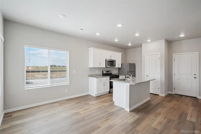 a kitchen with stainless steel appliances a refrigerator and a stove top oven