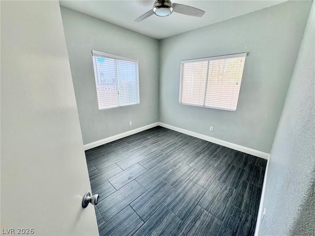5304 Runningbrook Road Las Vegas, NV 89120 - Photo 13 of 22 Dark wood-look flooring and dual windows elevate this versatile bedroom.