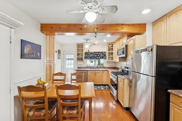 a kitchen with stainless steel appliances refrigerator dining table and chairs