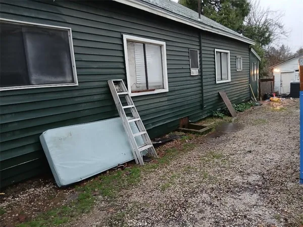 a view of a house with backyard and a trees