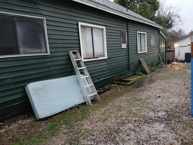 a view of a house with backyard and a trees