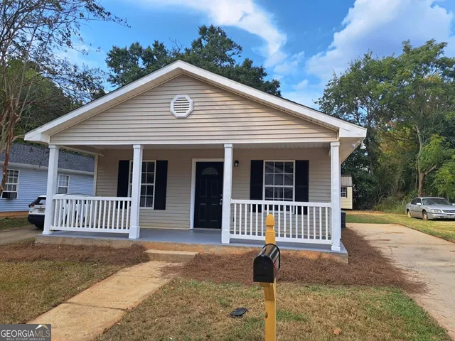 a view of a house with a yard and porch
