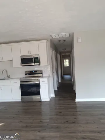 a kitchen with granite countertop a stove and a refrigerator