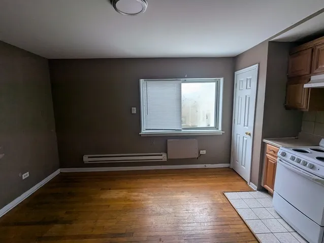 a view of an empty room with a fireplace and a window