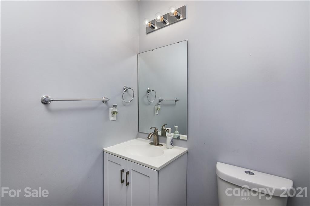 4615 David Cox Road Charlotte, NC 28269 - Photo 11 of 20 a bathroom with a sink a toilet and a mirror