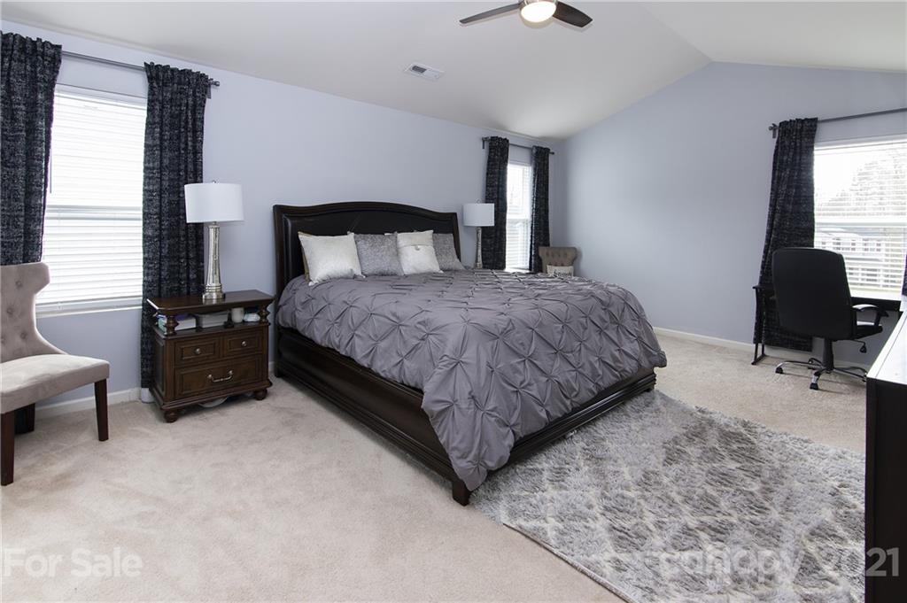 4615 David Cox Road Charlotte, NC 28269 - Photo 13 of 20 a bedroom with a bed and a chair