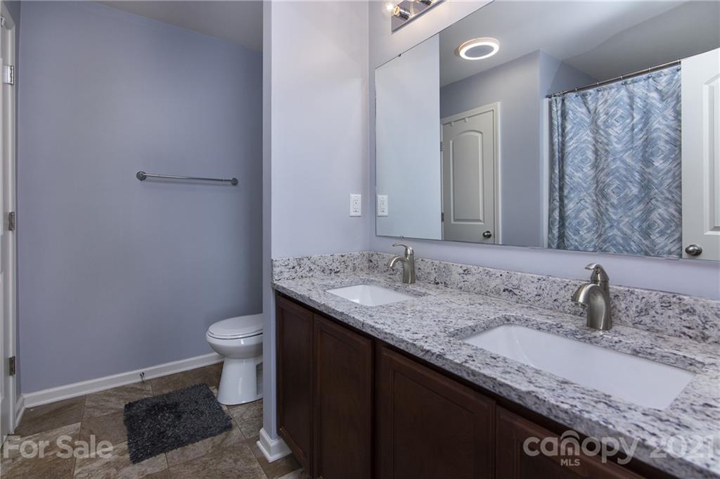 4615 David Cox Road Charlotte, NC 28269 - Photo 15 of 20 a bathroom with a granite countertop sink and a mirror