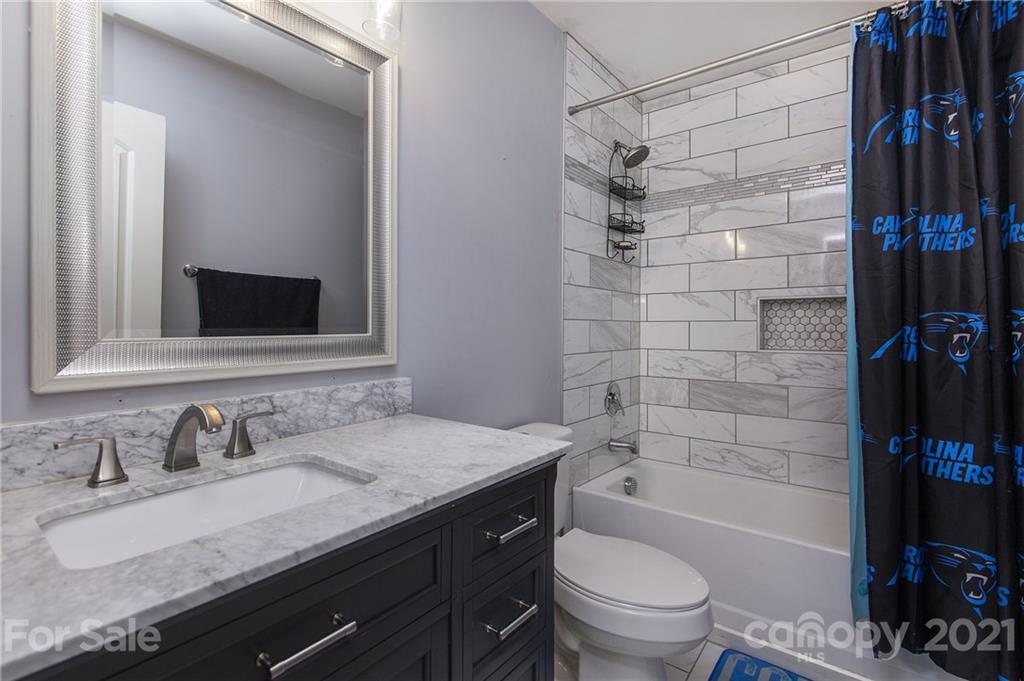 4615 David Cox Road Charlotte, NC 28269 - Photo 17 of 20 a bathroom with a granite countertop sink toilet and shower