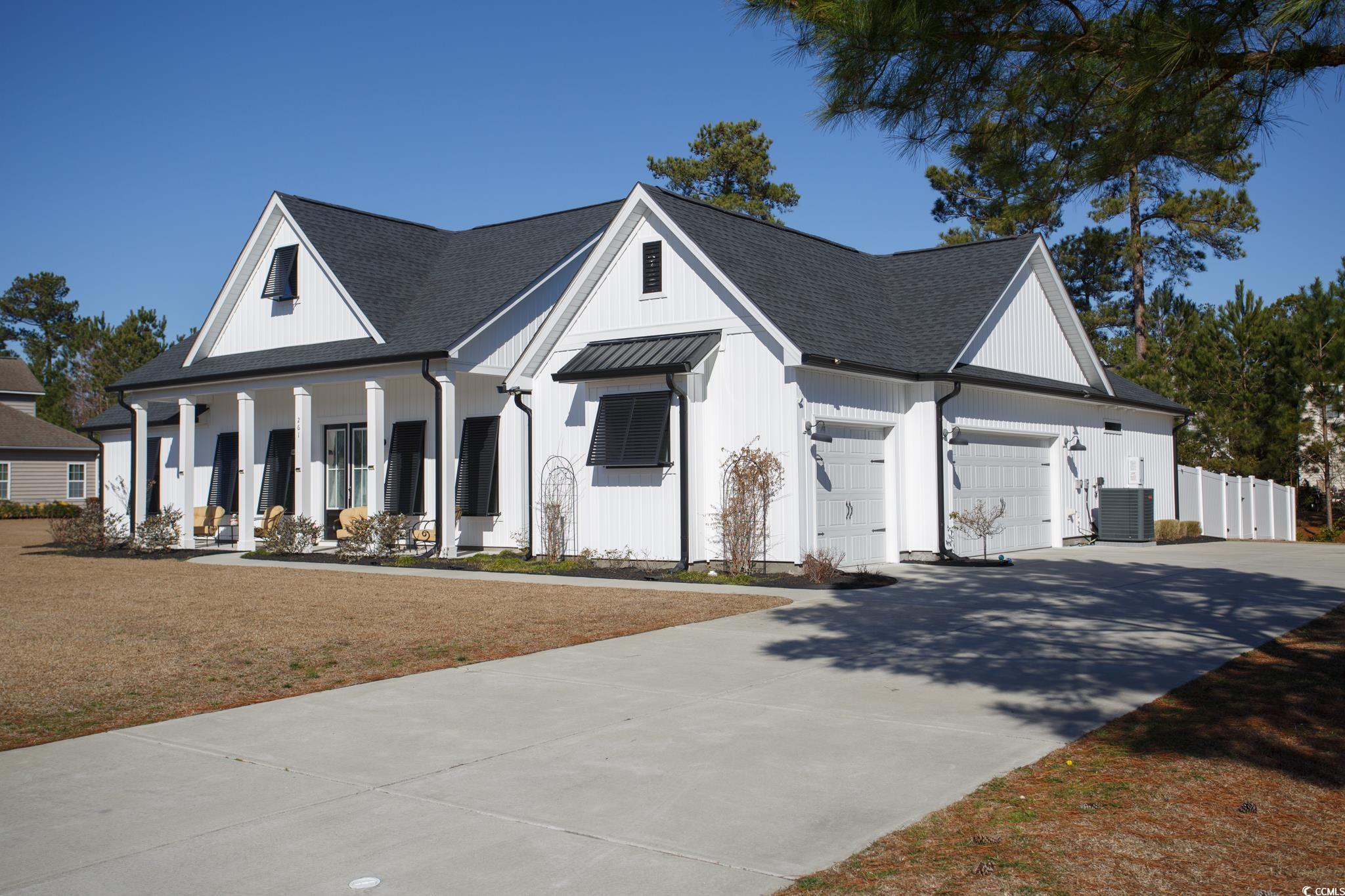 Modern inspired farmhouse featuring central AC, a garage, covered porch, and a front yard