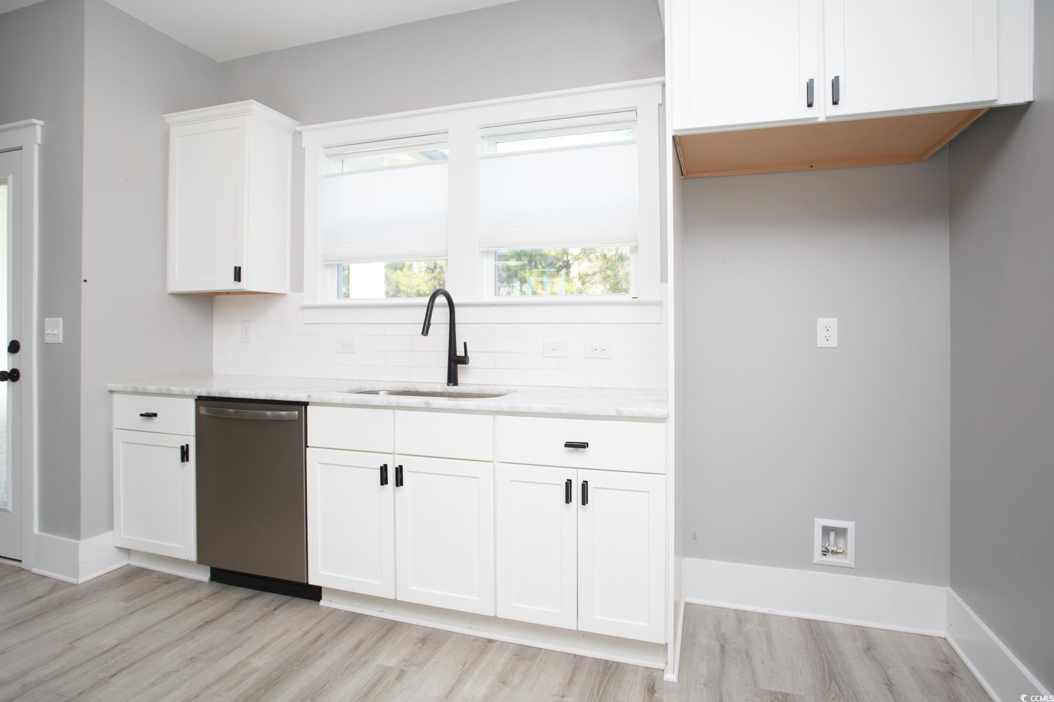 261 Marsh Tacky Loop Myrtle Beach, SC 29588 - Photo 13 of 40 Kitchen featuring sink, dishwasher, white cabinets, decorative backsplash, and light wood-type flooring