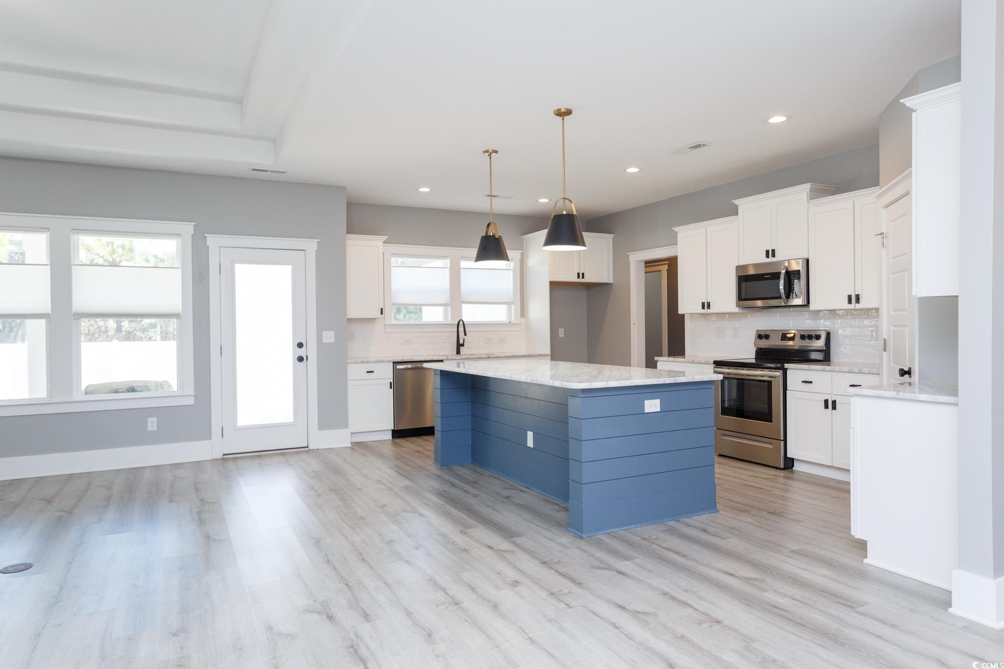 261 Marsh Tacky Loop Myrtle Beach, SC 29588 - Photo 8 of 40 Kitchen with white cabinetry, tasteful backsplash, a center island, appliances with stainless steel finishes, and pendant lighting