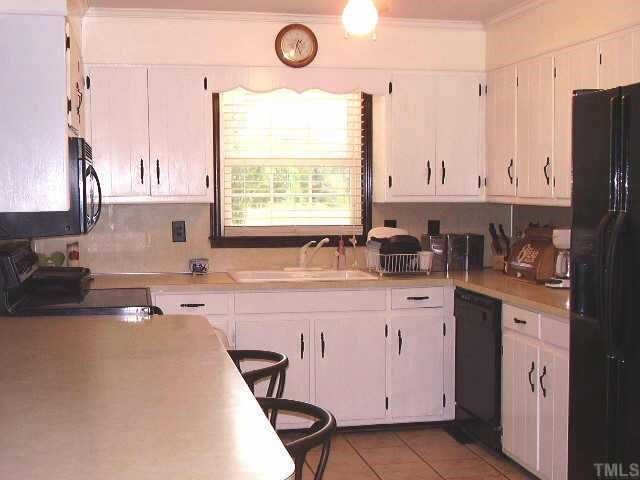 2777 Burlington Road Roxboro, NC 27574 - Photo 3 of 11 a kitchen with stainless steel appliances a sink a stove a refrigerator a counter space and cabinets