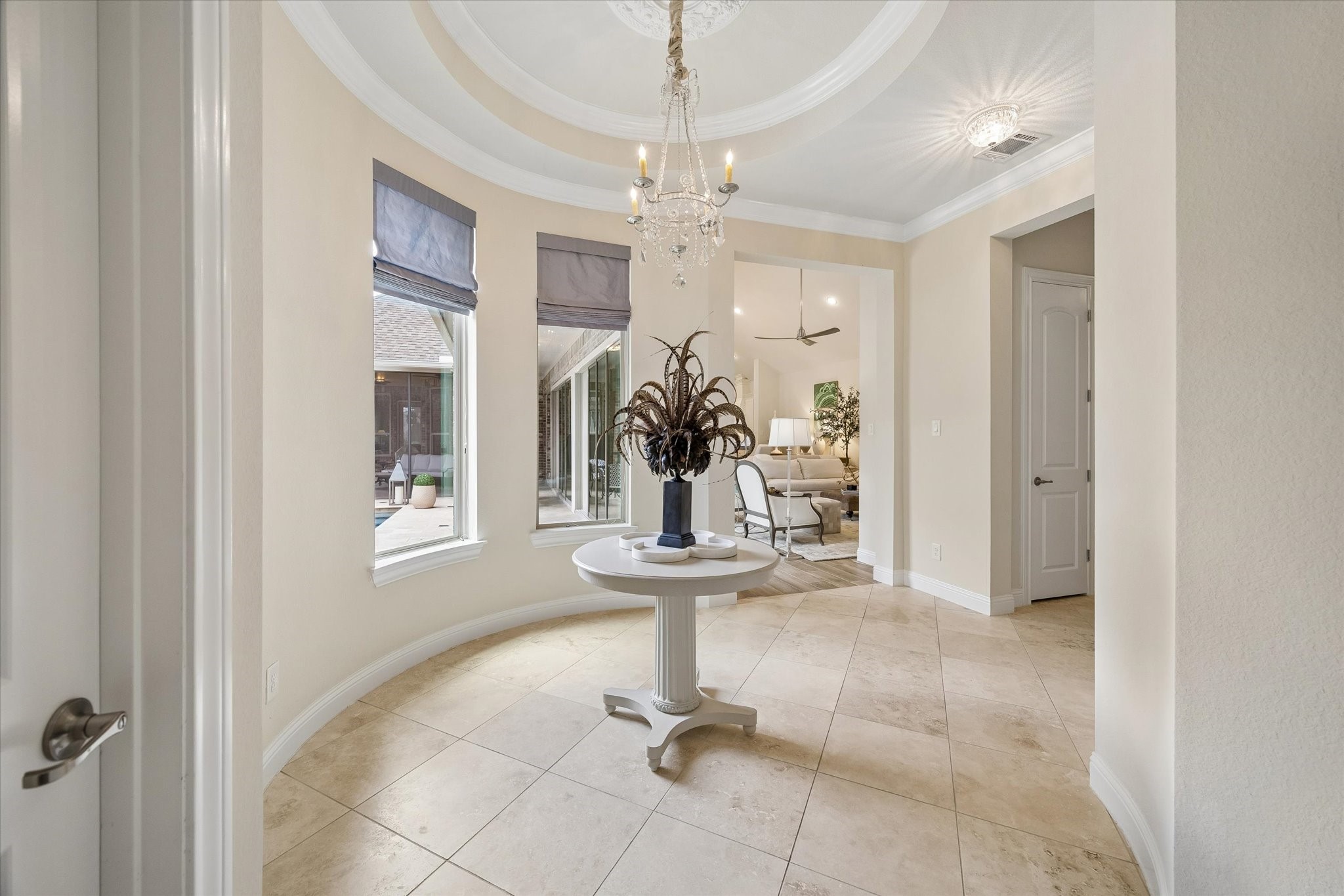 7418 Kearney Hill Lane Spring, TX 77389 - Photo 2 of 35 The circular formal entry is both architecturally pleasing with its tray ceiling and glimmering pendant but also functional, providing a buffer between the secondary bedroom wings and the living quarters. It features travertine floors.