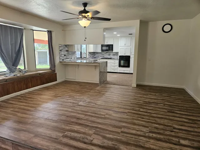 a view of kitchen with granite countertop cabinets window and stainless steel appliances