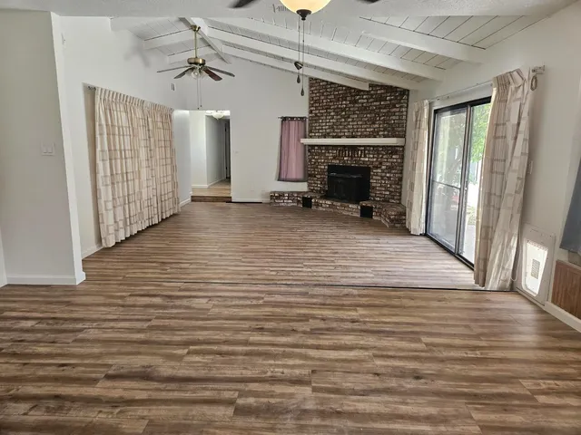 a view of a livingroom with wooden floor and a ceiling fan