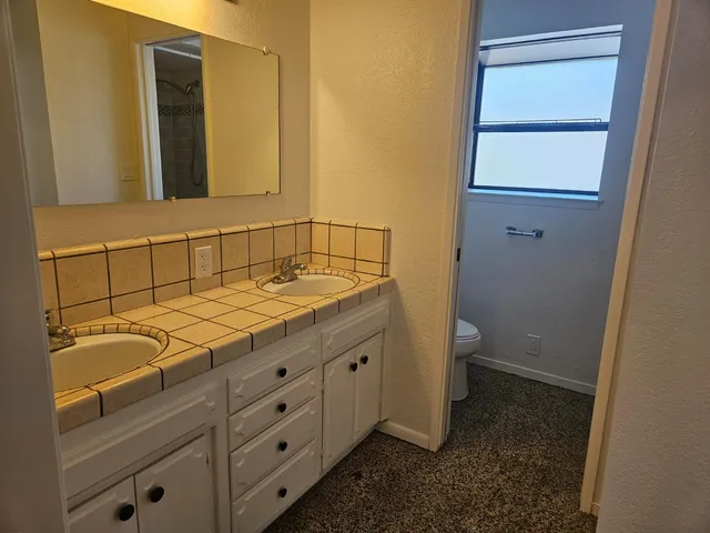 a bathroom with a granite countertop sink and a mirror