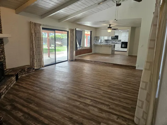 wooden floor in an empty room with a kitchen
