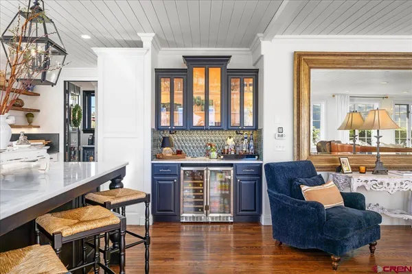 a living room with stainless steel appliances granite countertop a couch and wooden floor