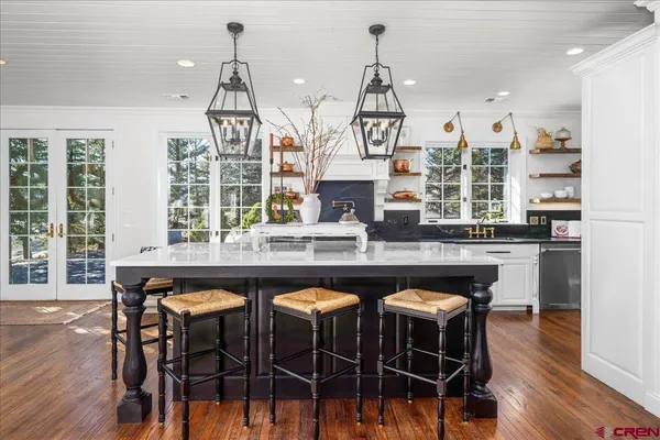 a kitchen with a table chairs stove and wooden floor