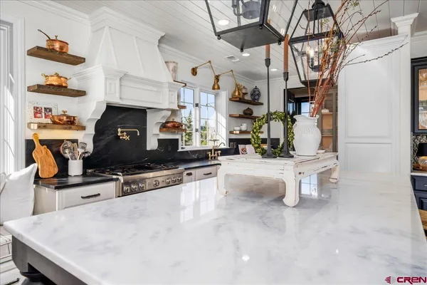 a kitchen with stainless steel appliances granite countertop a sink a stove and white cabinets