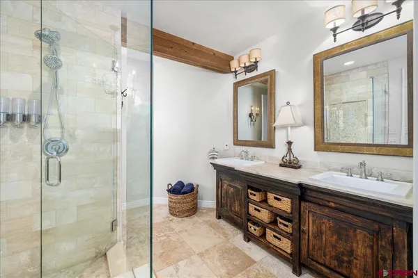 a bathroom with a granite countertop sink a mirror and shower