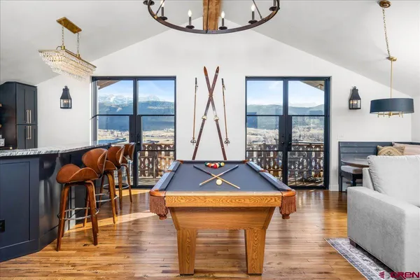 a living room with furniture a rug and a floor to ceiling window