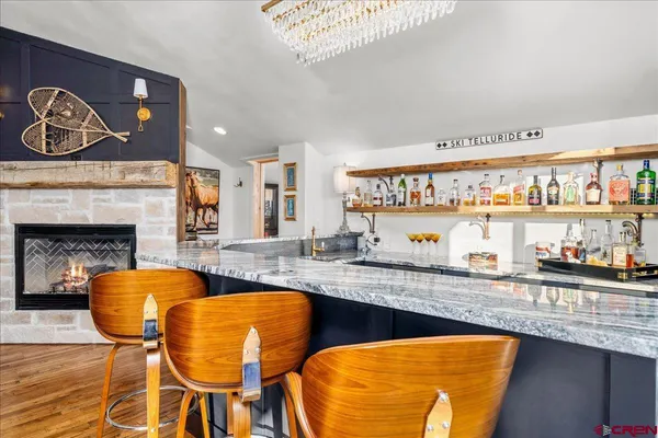 a kitchen with stainless steel appliances granite countertop a stove a sink and a dining table with wooden floor