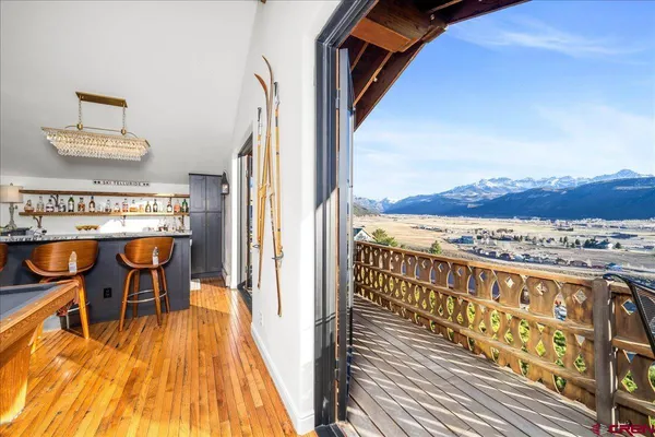 a view of a balcony with chairs and wooden floor
