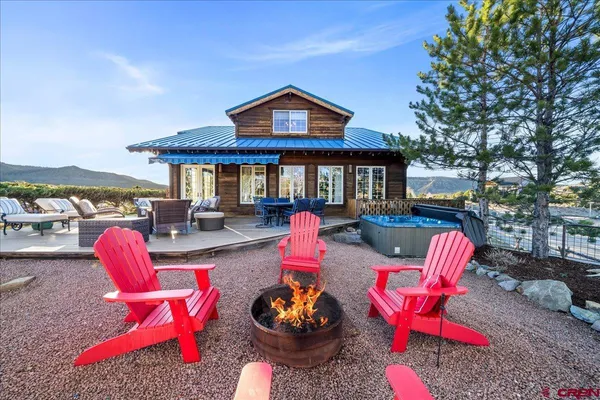 a front view of a house with swimming pool and sitting area