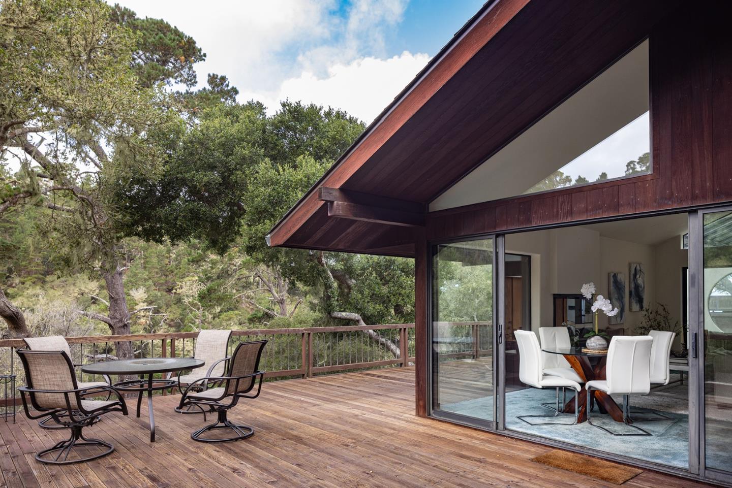 571 Viejo Road Carmel, CA 93923 - Photo 12 of 41 a view of a patio with table and chairs under an umbrella with wooden floor