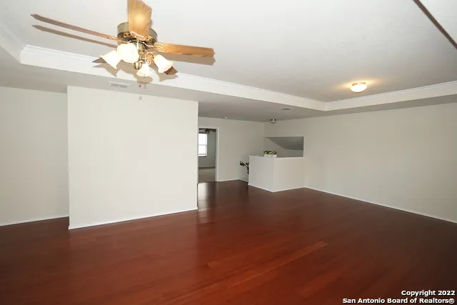 wooden floor in an empty room with a chandelier
