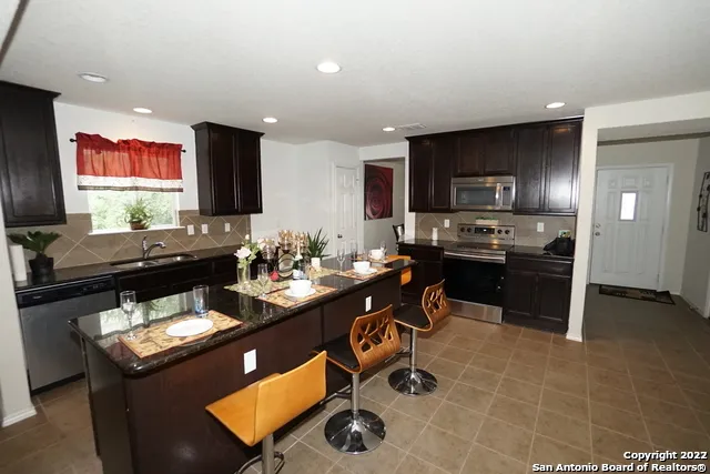 a kitchen with stainless steel appliances kitchen island granite countertop a sink and cabinets