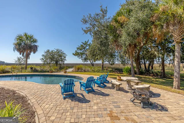 a front view of a house with swimming pool having outdoor seating