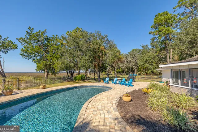 a view of swimming pool with lawn chairs yard