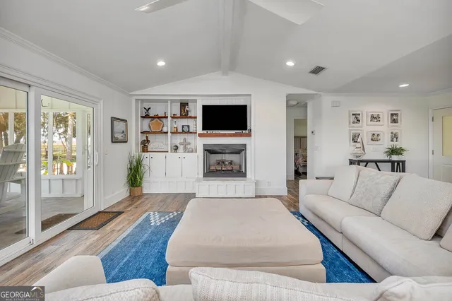 a kitchen with stainless steel appliances a stove a white cabinets and a wooden floor