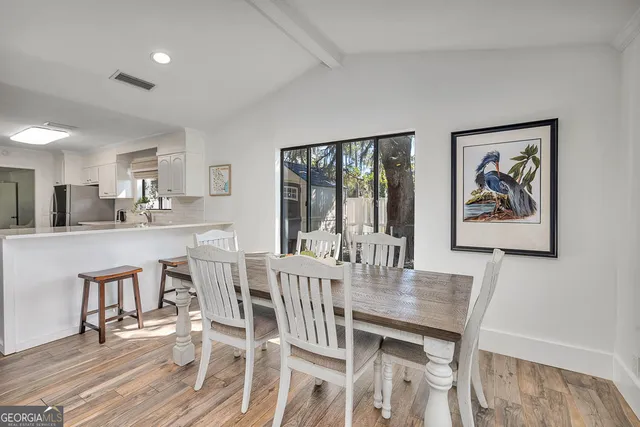 a living room with furniture a flat screen tv and kitchen view