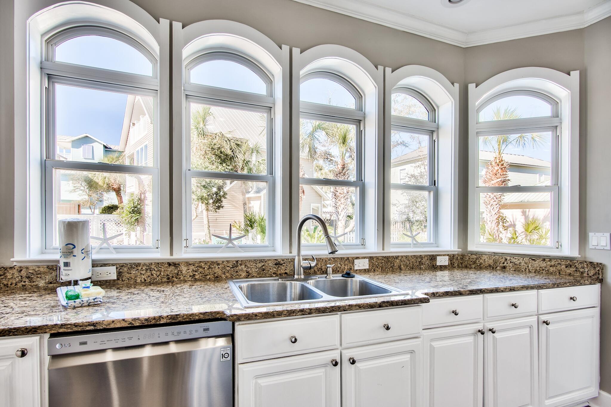 4489 Ocean View Drive Destin, FL 32541 - Photo 12 of 61 a kitchen with granite countertop a white cabinets a sink a window and stainless steel appliances