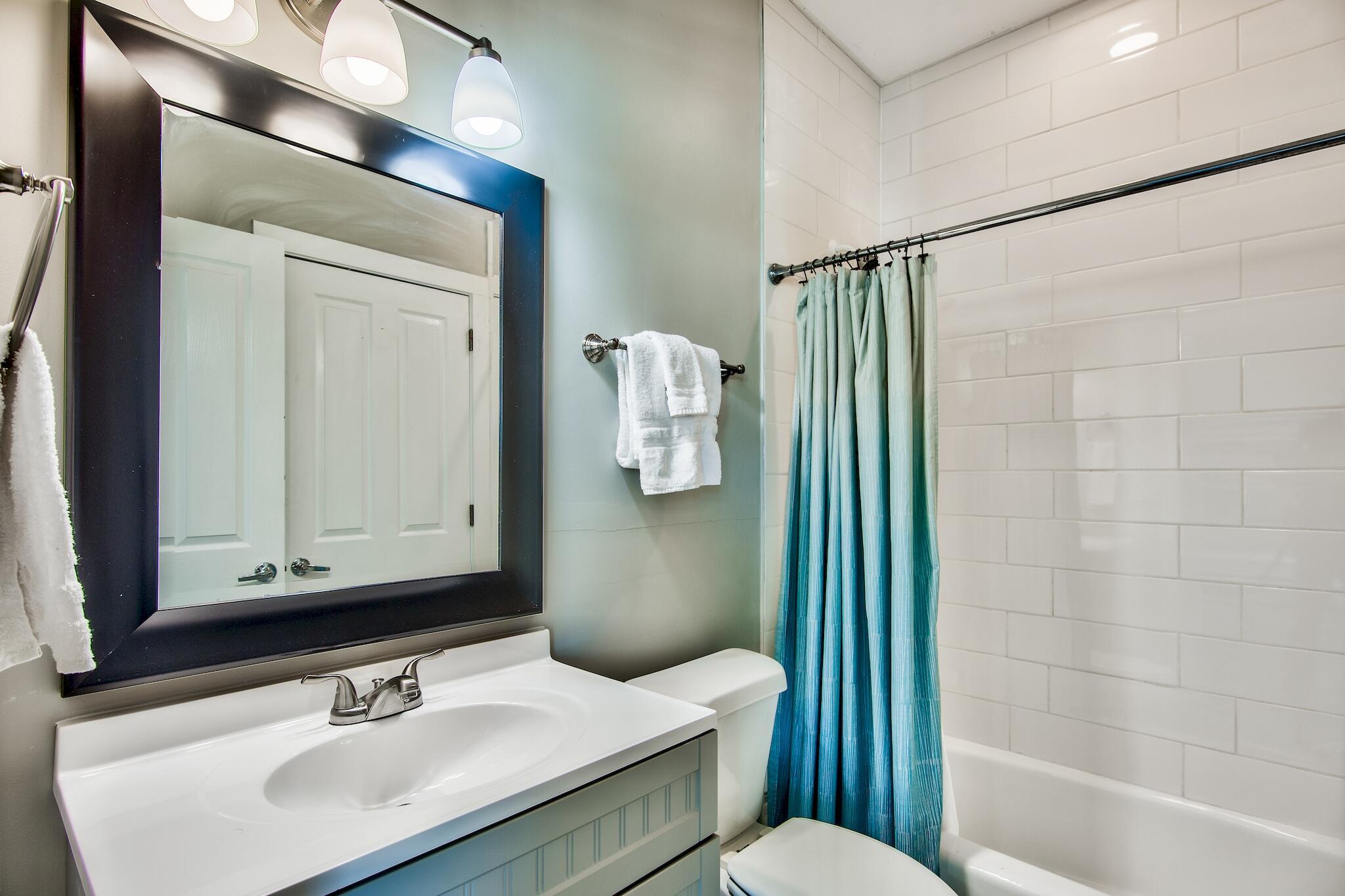 4489 Ocean View Drive Destin, FL 32541 - Photo 29 of 61 a bathroom with a sink a toilet a mirror and shower