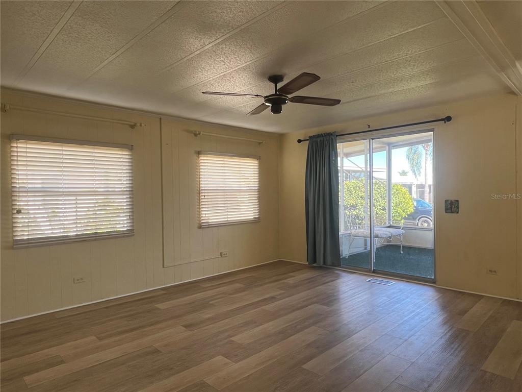 1100 South Belcher Road, Unit 185 Largo, FL 33771 - Photo 6 of 50 a view of an empty room with a window and wooden floor