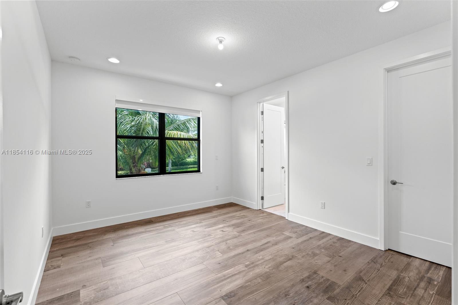17117 Teton River Road Boca Raton, FL 33496 - Photo 20 of 77 an empty room with wooden floor and windows