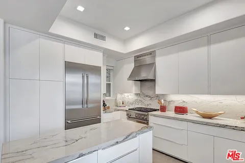 a kitchen with granite countertop a sink stainless steel appliances and cabinets