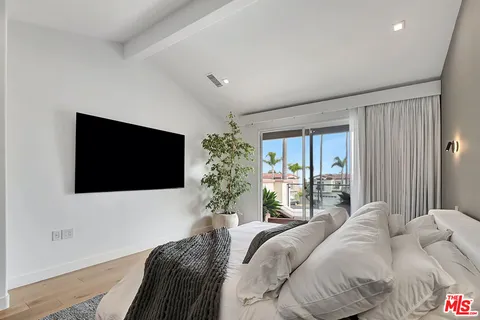a bedroom with a large bed and a flat screen tv