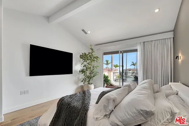 a bedroom with a large bed and a flat screen tv