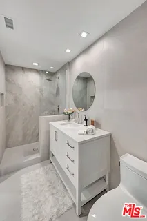 a bathroom with a sink a toilet and a mirror